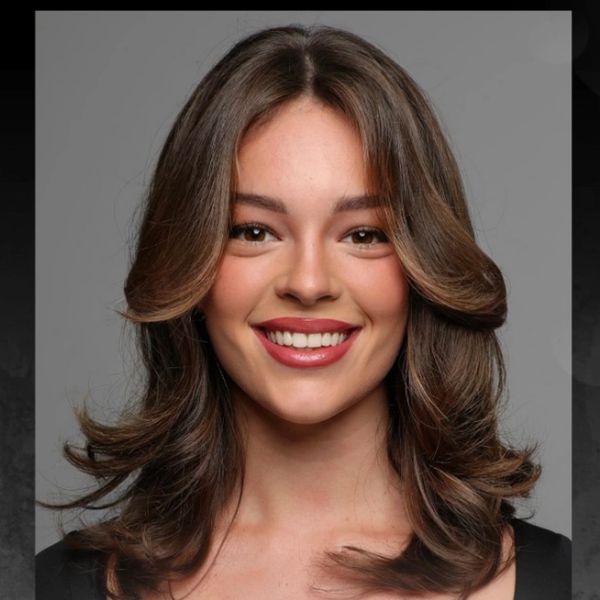 Smiling woman with shoulder-length styled hair and natural makeup.