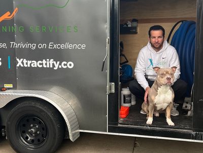 Matt Perez and his dog sitting in Xtractify trailer