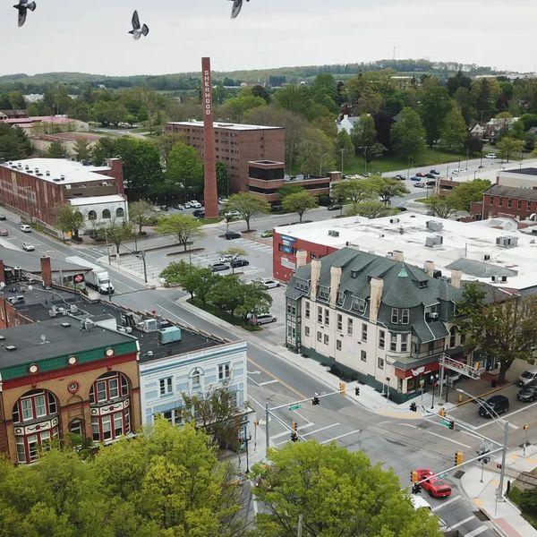 Aerial view of a small town with historic buildings and green trees.