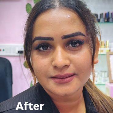 Close-up of a woman with freshly done makeup and bold eyebrows.