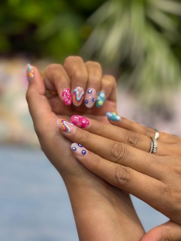 Colorful, artistic nail designs on well-manicured hands.