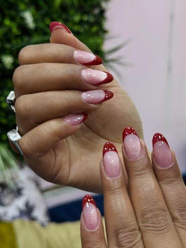 Close-up of hands with red-tipped French manicure.