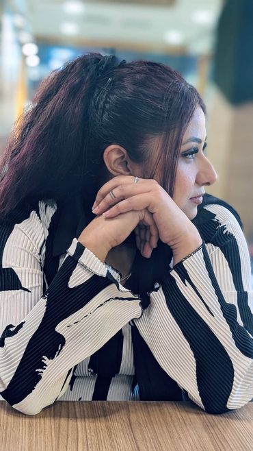 Woman in black and white striped top looking to the side.