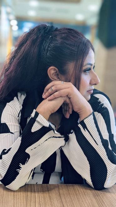 Woman in black and white striped top looking to the side.