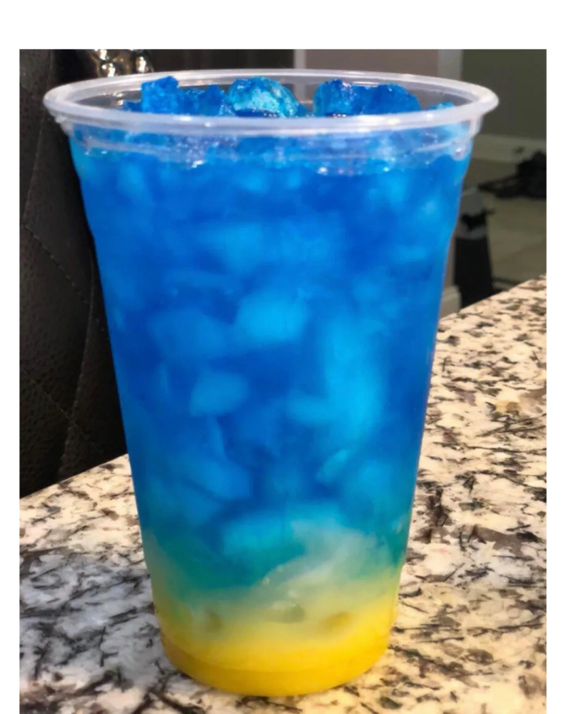 A vibrant blue and yellow layered iced drink in a clear plastic cup.
