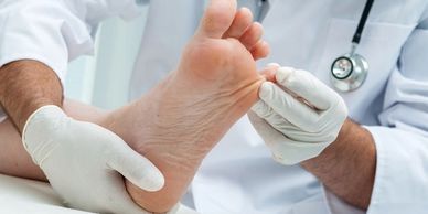 A podiatrist is examining a patient's foot carefully.