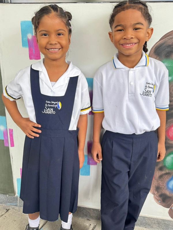 Niños con uniformes escolares sonriendo.
