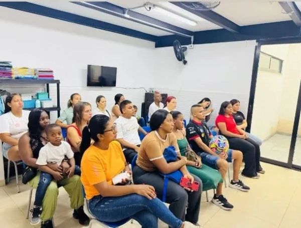 A group of people seated attentively in a bright room.