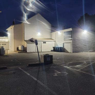 Night view of a well-lit pharmacy building with empty parking spaces.
