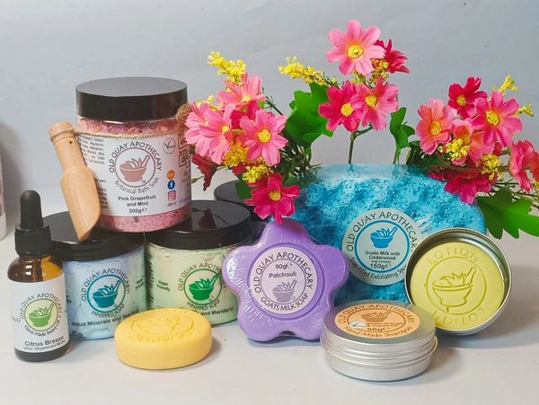 Old Quay Apothecary skincare products arranged with pink flowers.