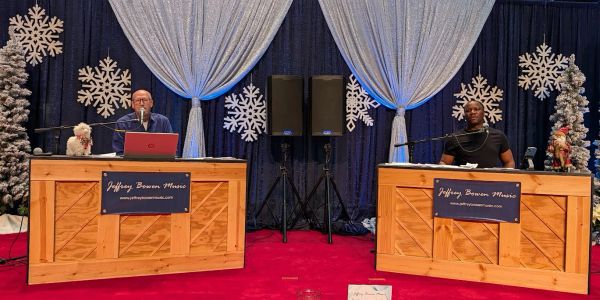 Two musicians performing on wooden pianos in a festive winter setting.