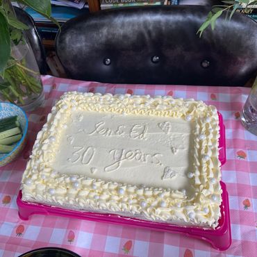 Celebratory cake for 30 years with decorative icing on a pink tablecloth.