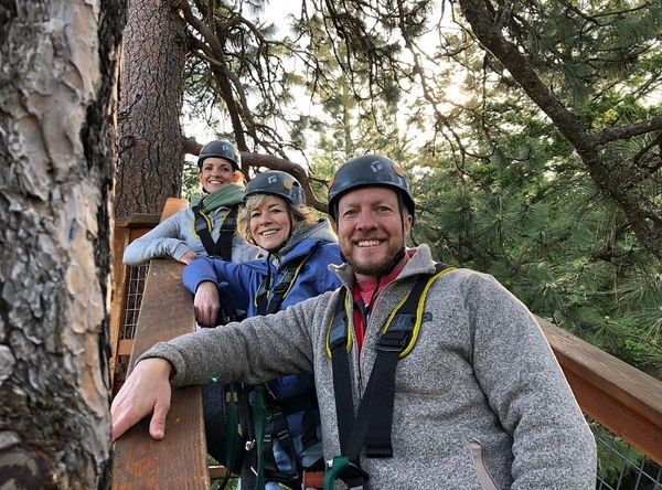family of three smiling on staircase