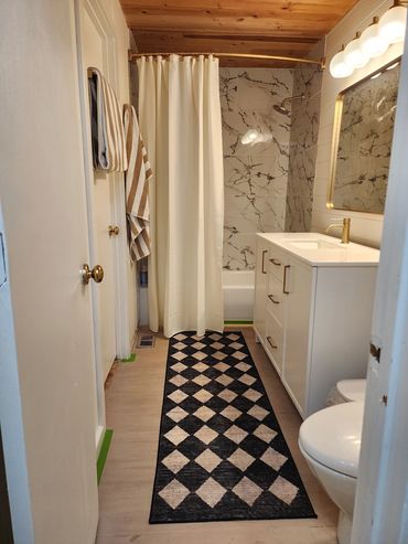 Renovated bathroom with fresh paint, upgraded vanity, shower upgrade & updated lighting fixtures.
