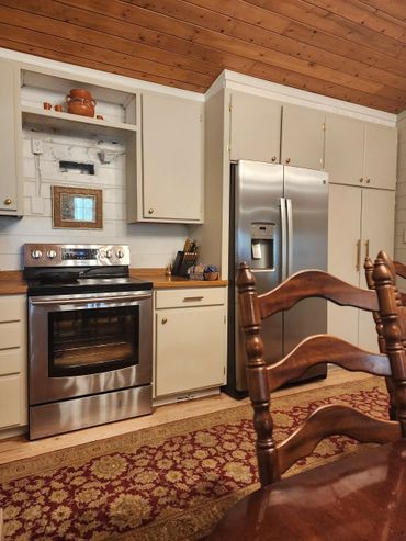 Kitchen renovation featuring sanded cabinets, new hinges, and updated hardware to save on costs.