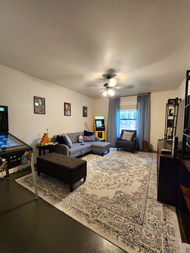 Spacious garage converted into a family entertainment room and functional office.