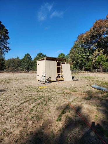 Spacious wooden chicken coop with secure wire run in a backyard setting