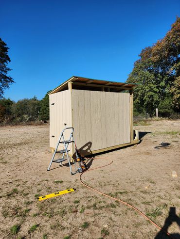 Newly built chicken coop with large outdoor run for free-range hens.
