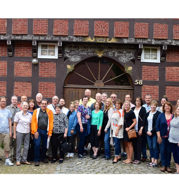 Group photo in front of a traditional brick and wooden building.