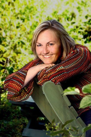 portrait of a woman leaning on the back of a chair in an outdoor setting
