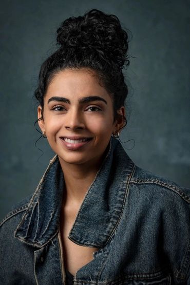 portrait of a young woman wearing a denim jacket in a studio