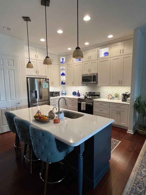 Tall white cabinets with  corner glass cabinets for display & a  large island with comfy seating