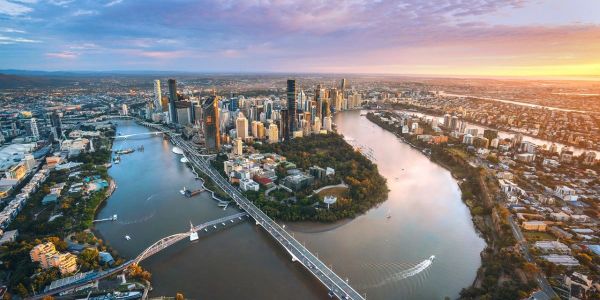 Aerial view of a city with a river winding through and bridges crossing it at sunset.