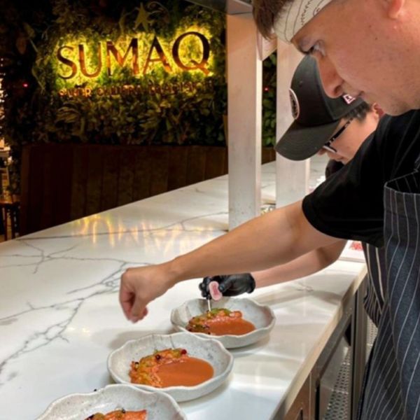 Chef garnishing dishes at Sumaq restaurant's counter with precision. Sumaq Restaurant