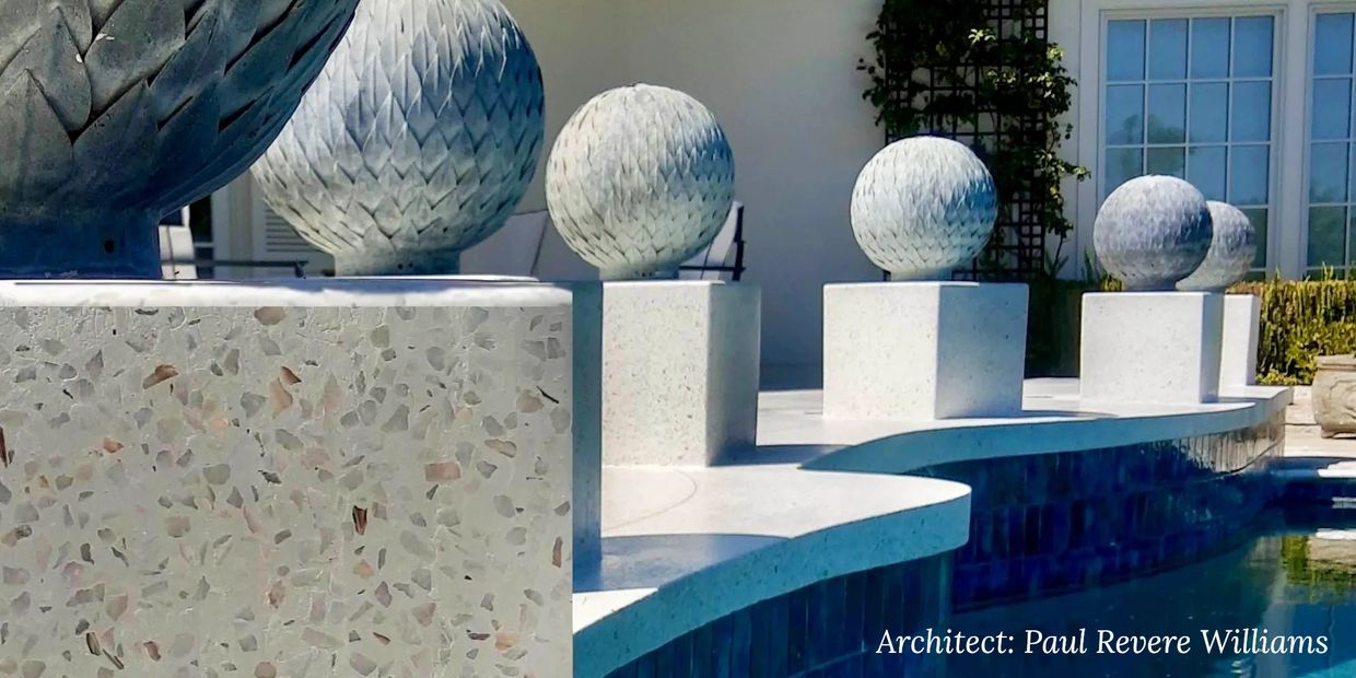 Artistic spherical sculptures by a pool.