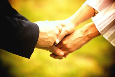 a couple holding hands during their wedding handfasting ceremony
