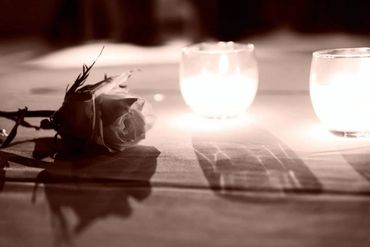 A rose on a candlelit table during a wedding handfasting
