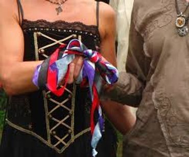 A couple performing the rite of handfasting