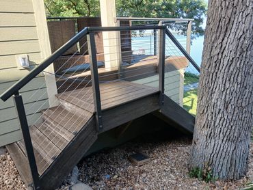 Two-sided composite stairs with cable railing and decking by Thomm & Murf Remodeling, Madison, WI.