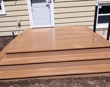 Composite deck with wrap-around picture frame stairs by Thomm & Murf, deck builders in Madison, WI.