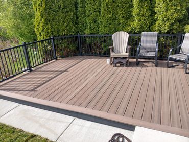 Picture frame composite deck with sleek black railing by Thomm & Murf, deck builders in Madison, WI.