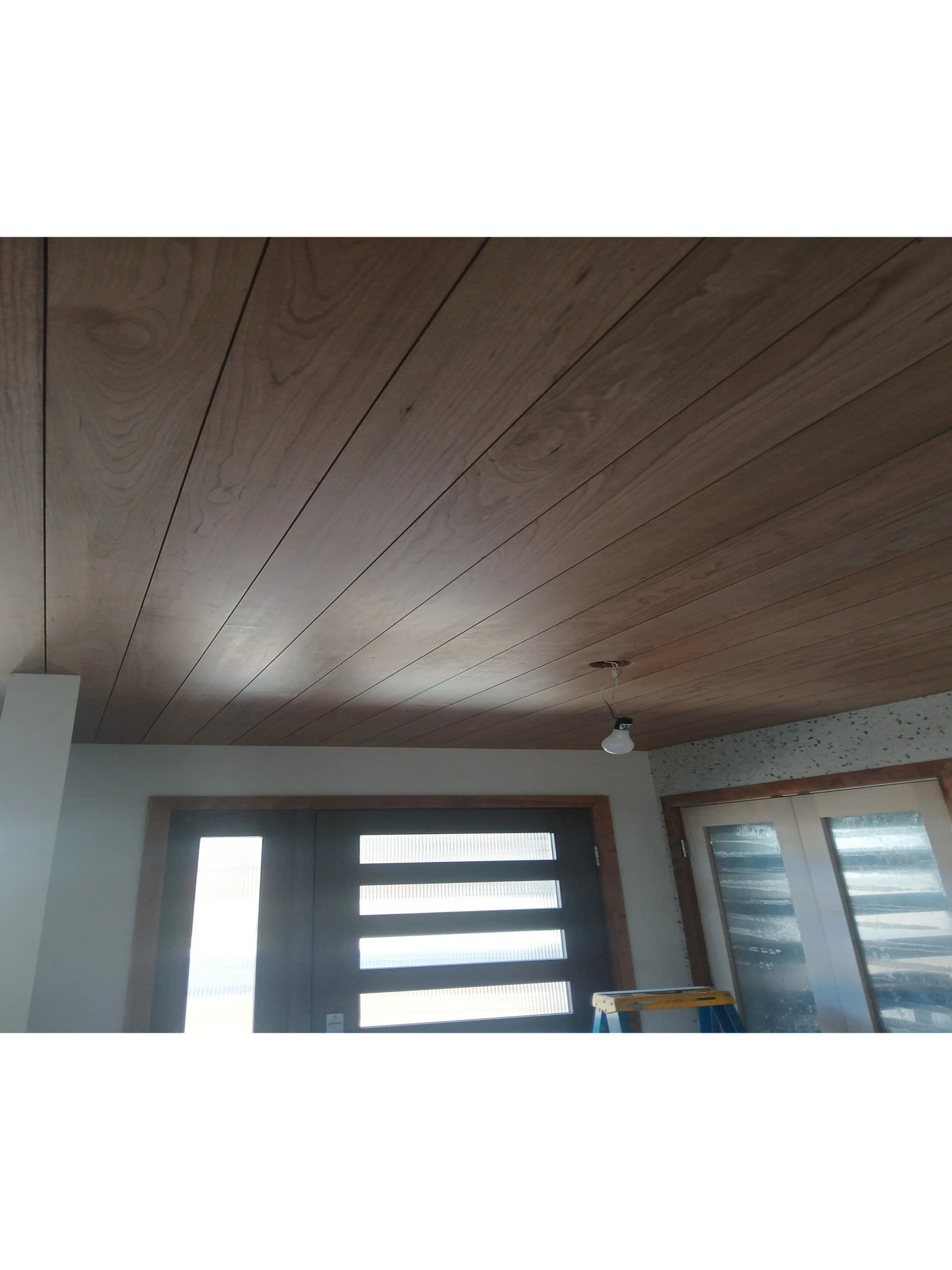 Finished basement remodel featuring a nickel gap wood ceiling and modern trim in Madison WI