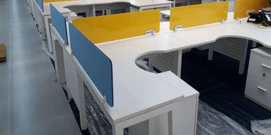 office workstations in Noida with L shape table top and blue and yellow color partitions