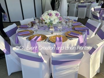 Elegant round table set for an event with purple and white decor.
