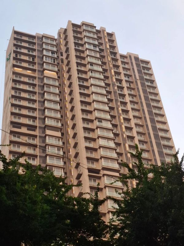 Modern high-rise residential building against a clear sky.