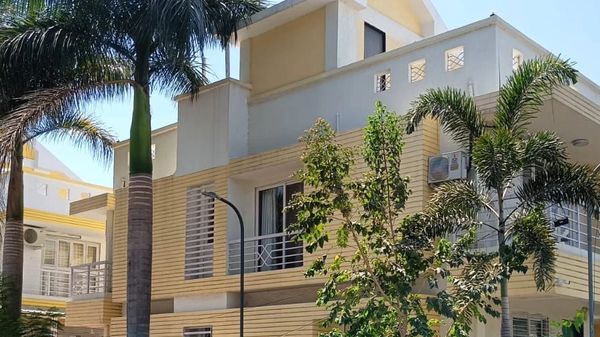 Modern two-story house with palm trees.