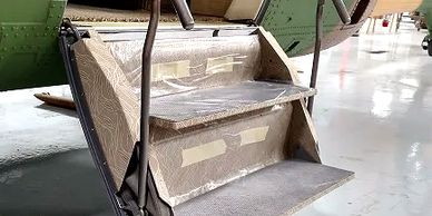 Close-up of an aircraft's foldable stairs, featuring three steps and handrails.