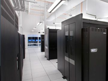 Modern data center room with server racks and bright lighting.