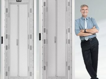 A man in business attire leaning against a large, white server rack.