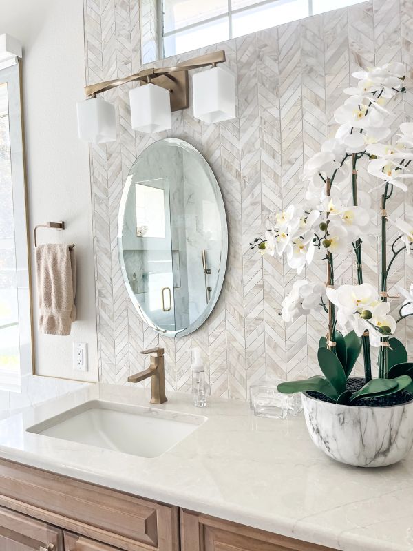 Elegant bathroom vanity with marble countertop and white orchids.