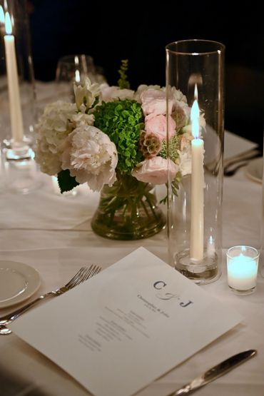 Elegant table setting with floral centerpiece and lit candles for a special event.