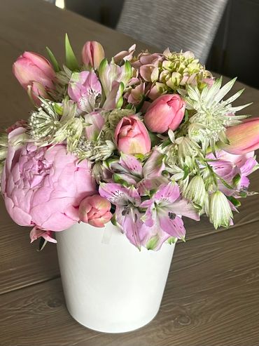 Elegant bouquet of pink and white flowers in a white vase.