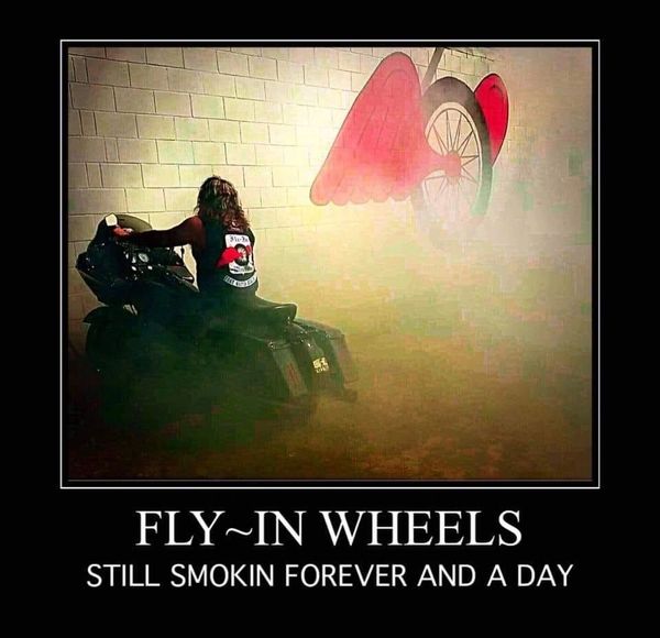 Biker on motorcycle with smoke and winged wheel mural.