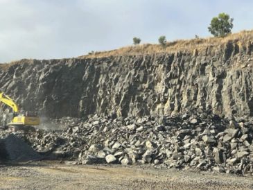 Excavator working on rocky terrain.