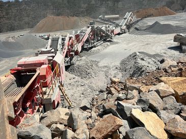 Industrial rock crushing machines at a quarry site.