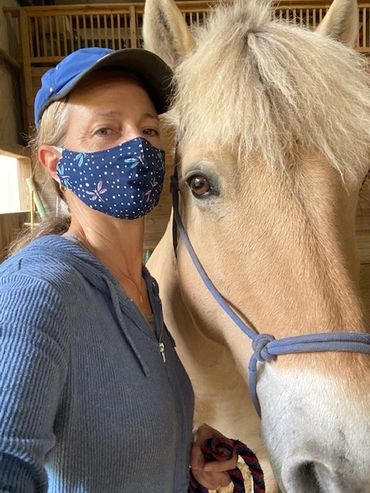 A selfie of a woman beside a pony's face; both are looking at the camera.